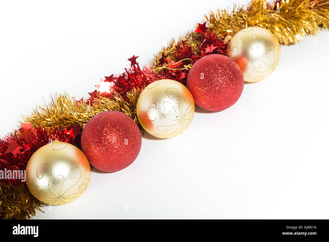 Christmas decorations red and golden color on a white background - balls and tinsel Stock Photo