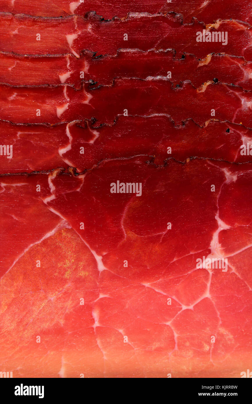 Smoked ham. Italian speck red meat slices isolated on studio background