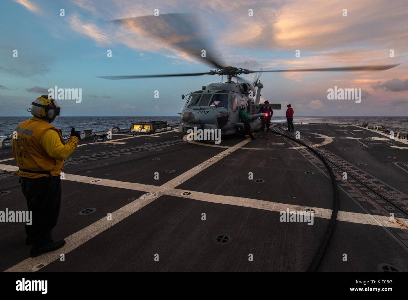 A U.S. Navy MH-60R Seahawk helicopter lands aboard the U.S. Navy Arleigh Burke-class guided-missile destroyer USS Halsey November 17, 2017 in the Philippine Sea.  (photo by Nicholas Burgains via Planetpix) Stock Photo