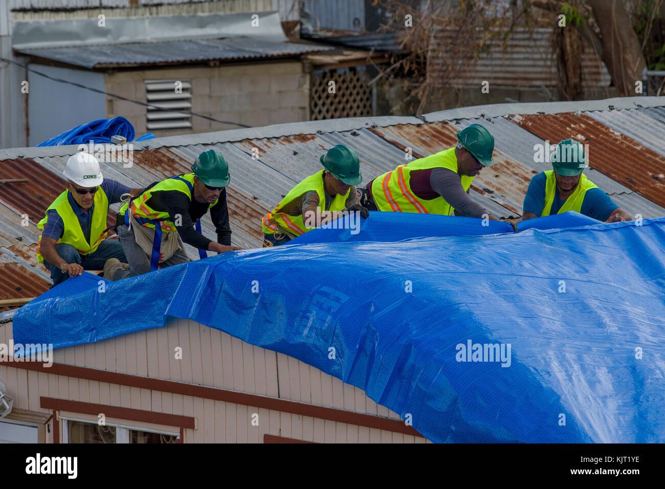 U.S. Army soldiers replaced damaged roofs with blue plastic tarps during relief efforts in the aftermath of Hurricane Maria October 28, 2017 in Ponce, Puerto Rico. (photo by Avery Cunningham via Planetpix) Stock Photo