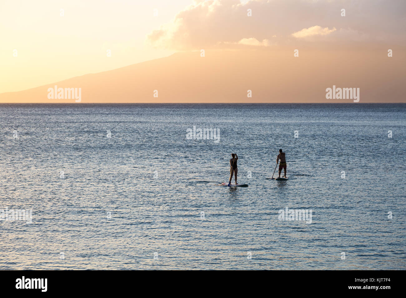 Silhouette of two standup paddlers at the north shore of Maui, Hawaii Stock Photo
