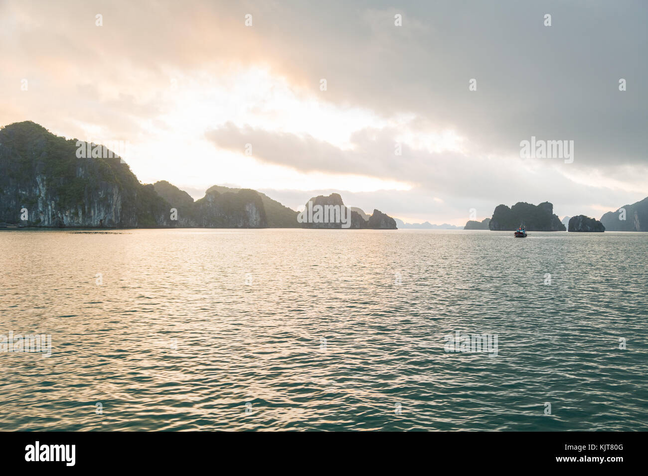 Halong Bay early in the morning with a small boat in the background Stock Photo