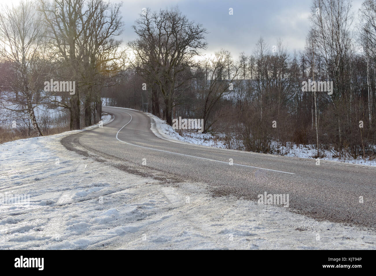 country road in winter with tyre tracks in the snow and ice Stock Photo ...