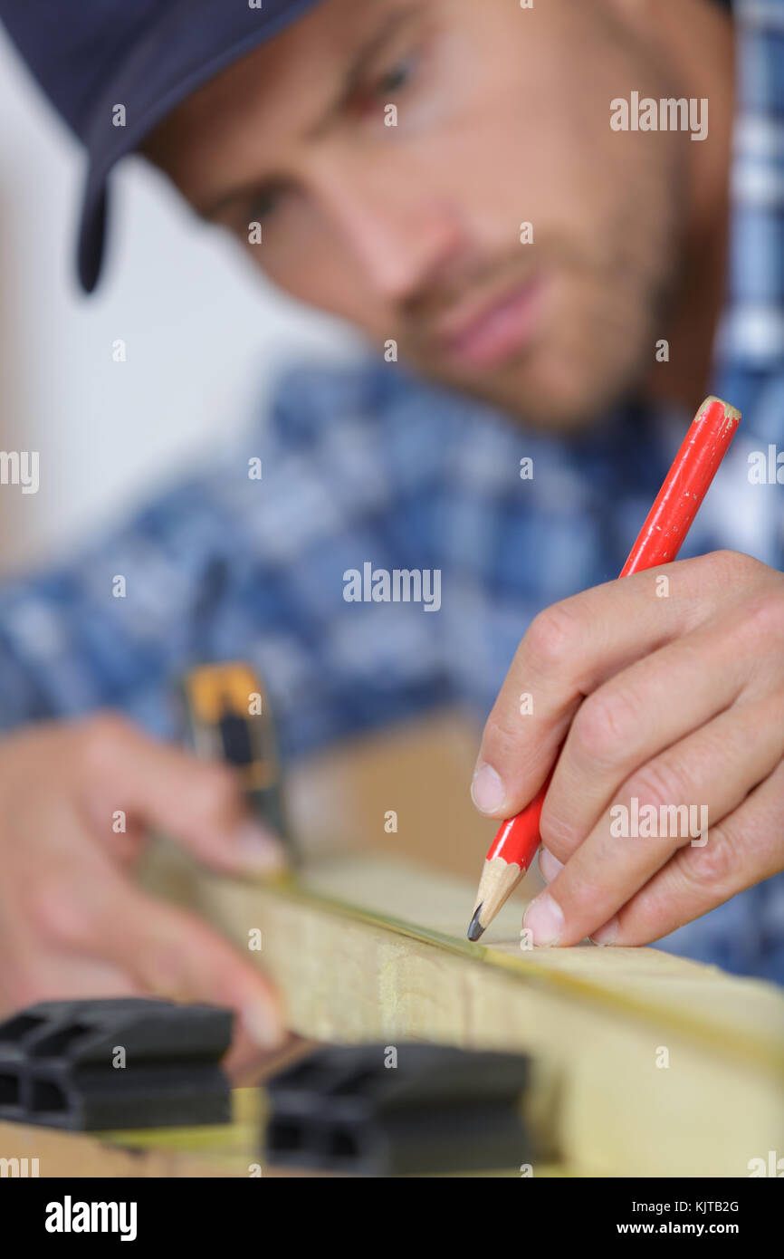 carpenter plans project and writes at drawings in workshop Stock Photo ...