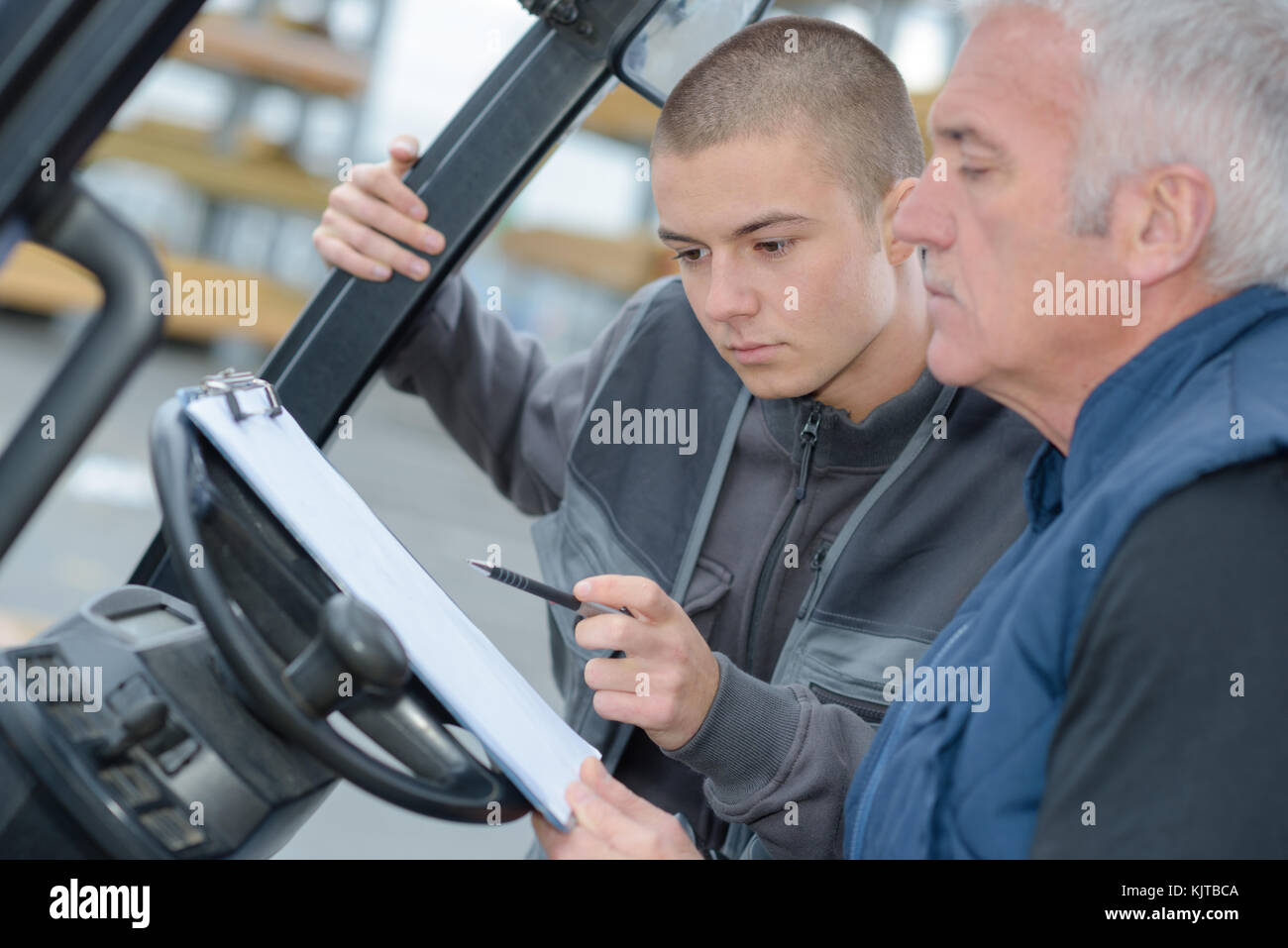 Forklift driver reading clipboard Stock Photo Alamy
