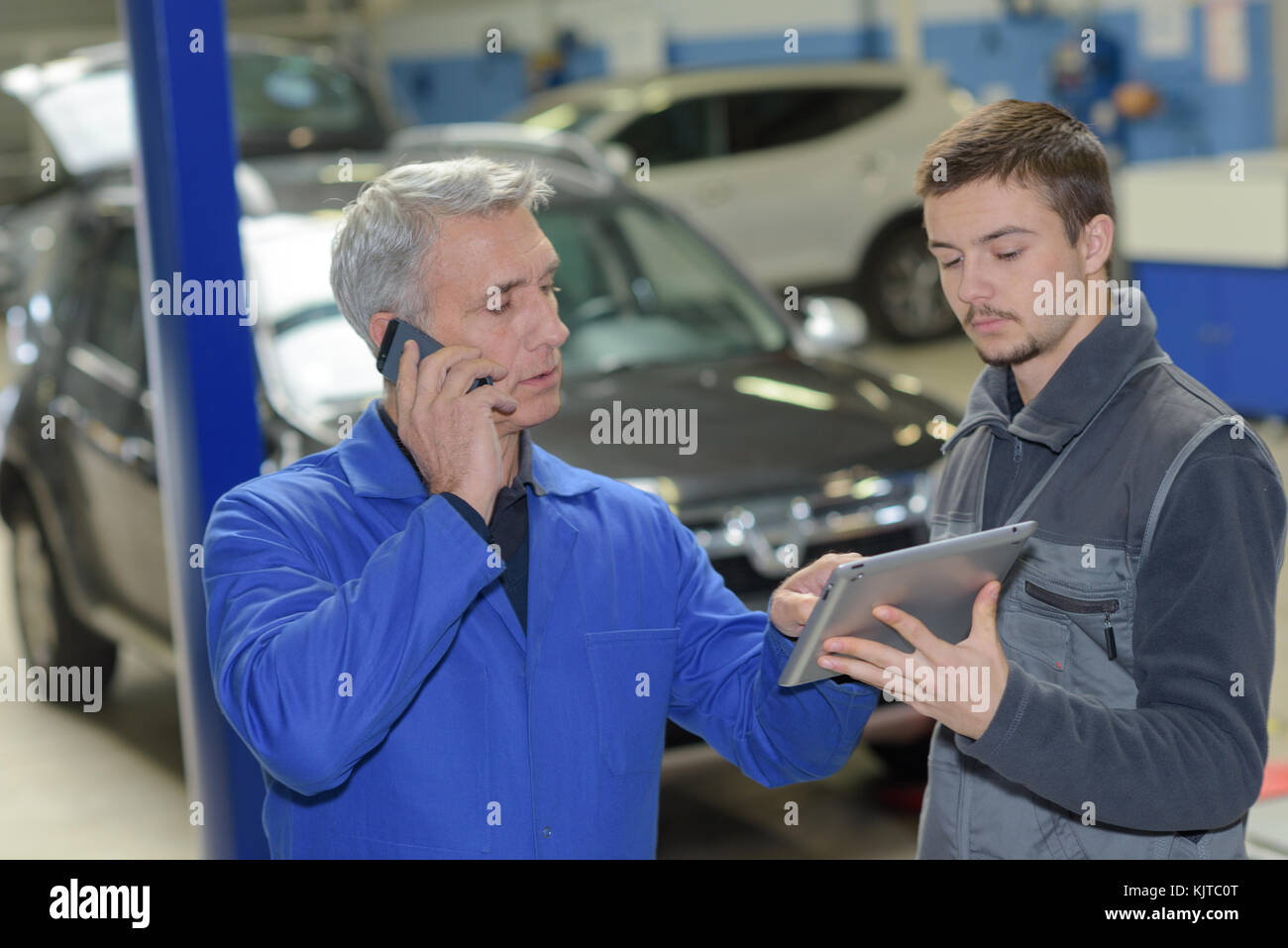 student with instructor repairing a car during apprenticeship Stock