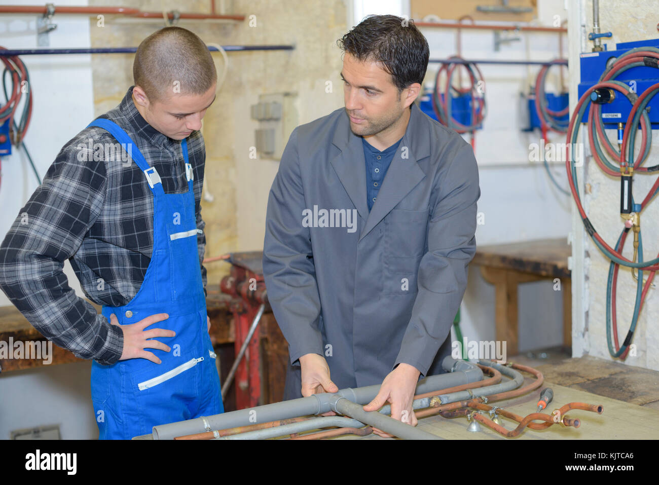 plumber and apprentice at workshop Stock Photo - Alamy