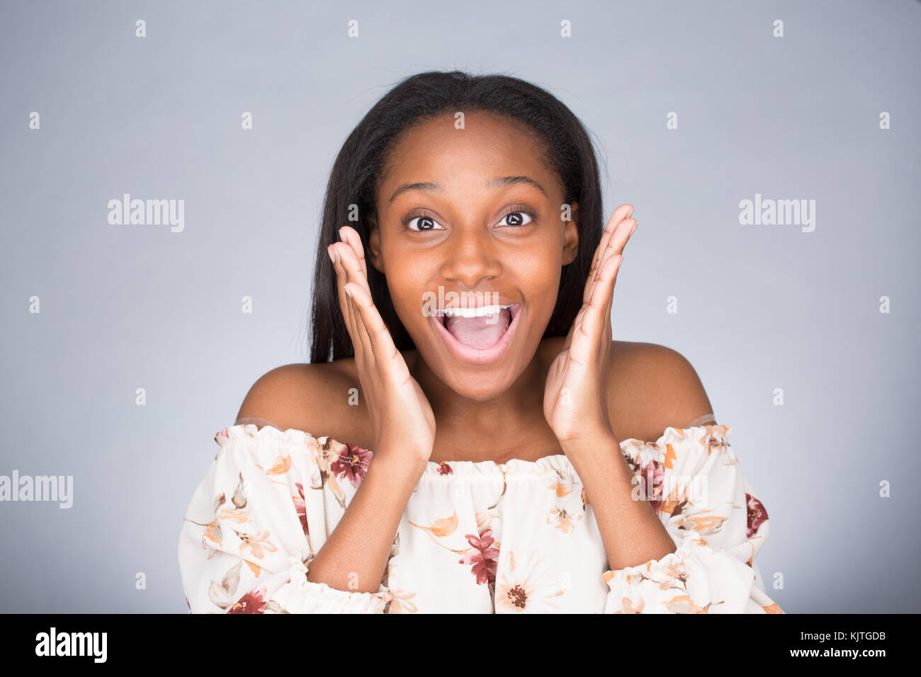 Closeup portrait of happy cute young beautiful woman taken aback in disbelief hands on face isolated gray background. Positive human emotion, facial e Stock Photo