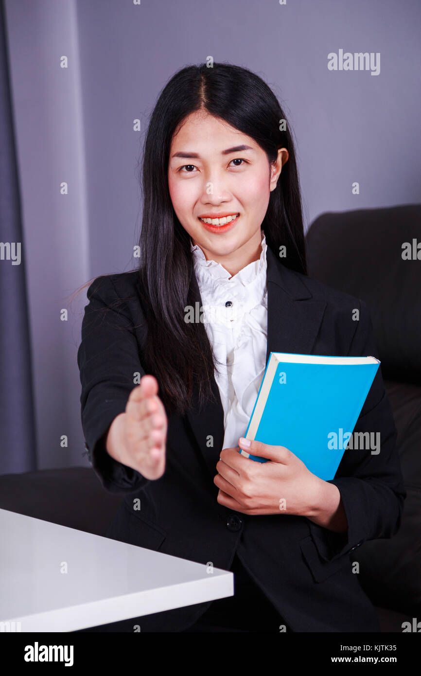 young business woman holding a book and gives a handshake Stock Photo ...