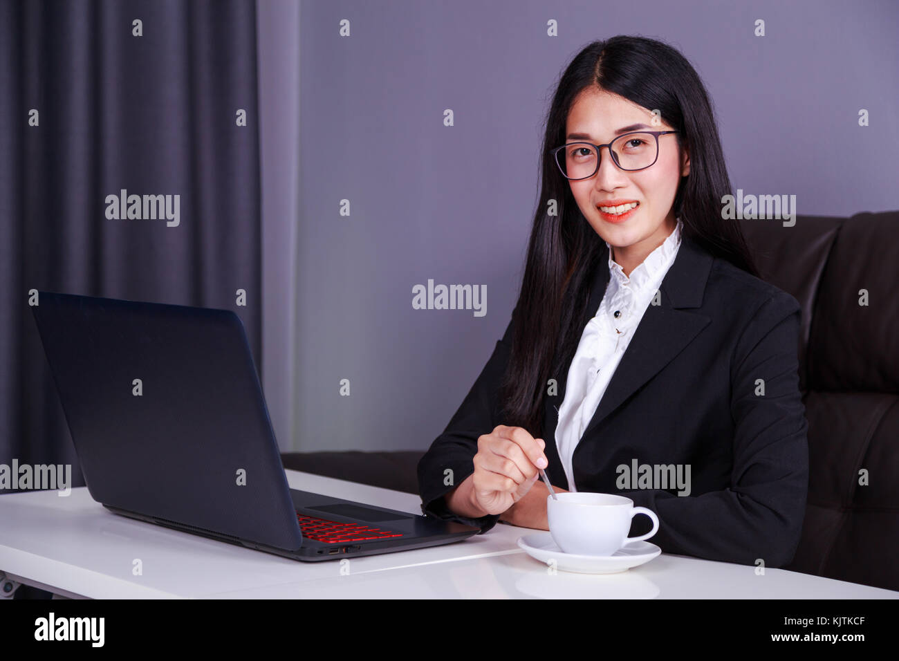happy young business woman working on laptop computer and drinking a ...