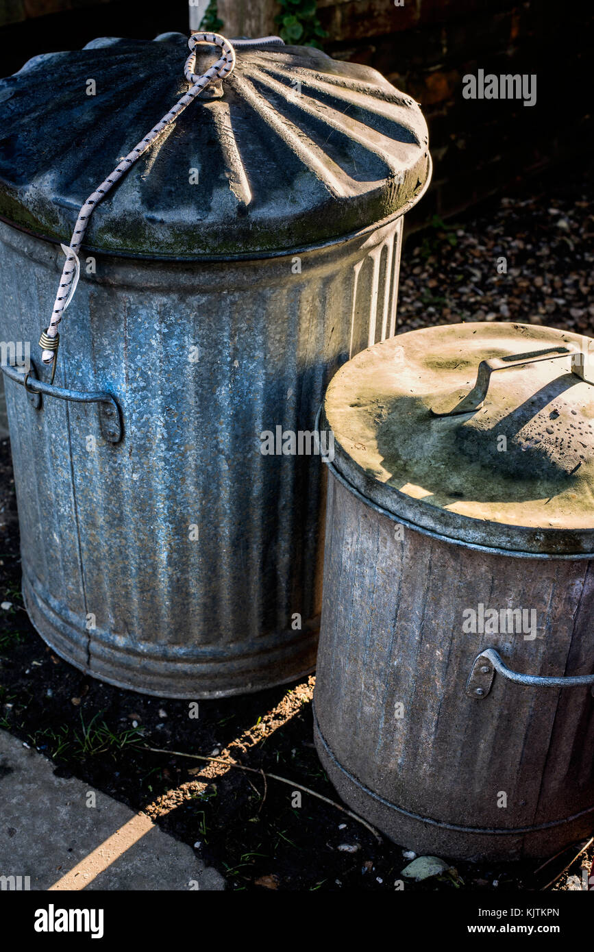 Traditional metal bins in an alley with sun coming through Stock Photo
