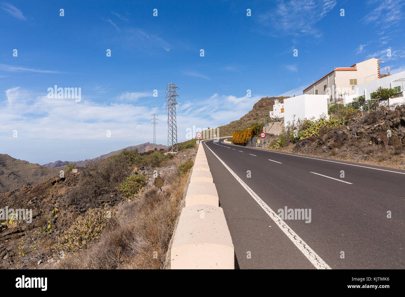 Mountain road with electricity pylons passing the village of Arguayo, in Santiago del Teide, Tenerife, Canary Islands, Spain Stock Photo