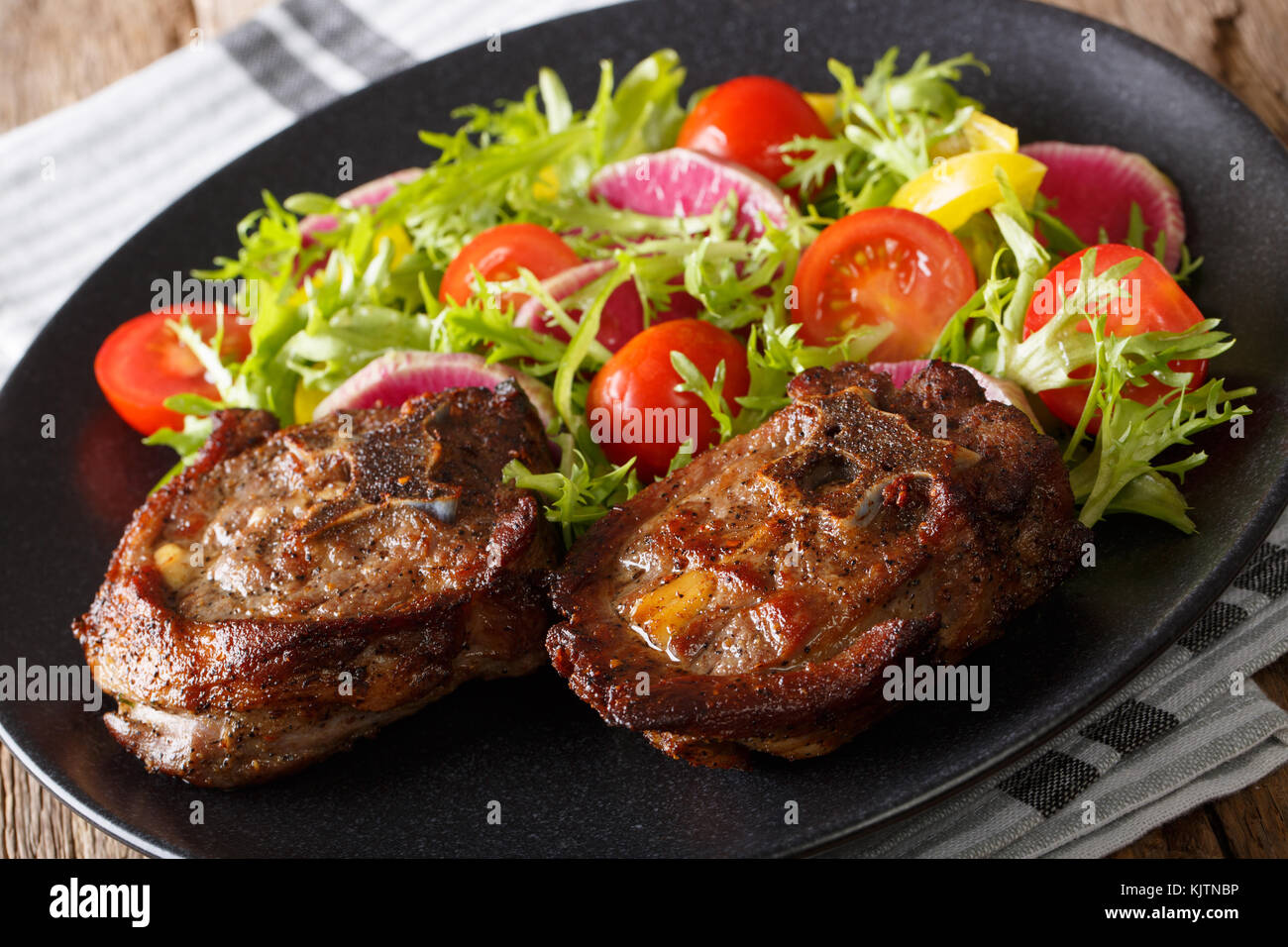 Roasted lamb steak and vegetable salad from radish, tomatoes, pepper