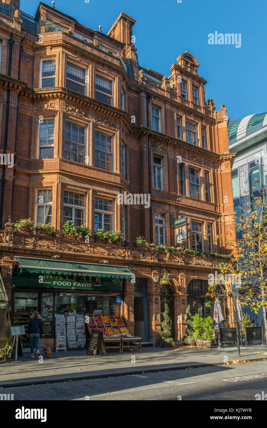 Shop and pub on 19th century buildings in Mayfair, London, UK on a sunny day Stock Photo