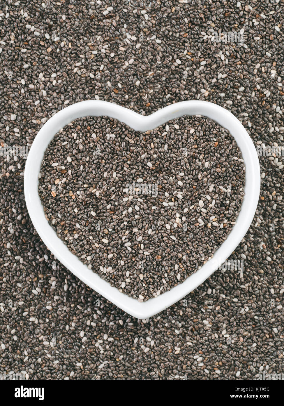Heart-shaped bowl of chia seeds Stock Photo