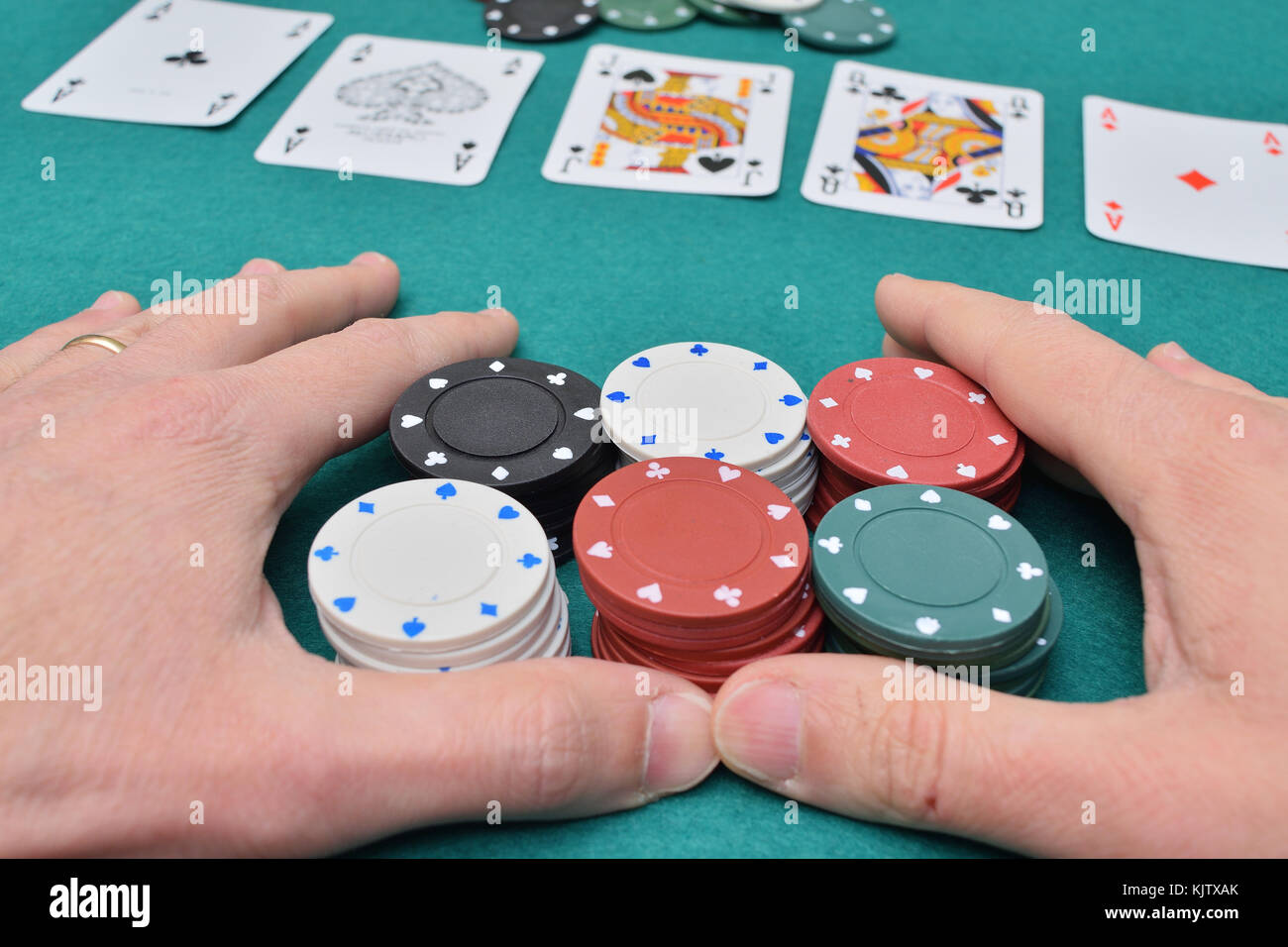 Stack of poker chips in two hands and cards on a gambling table with chips Stock Photo