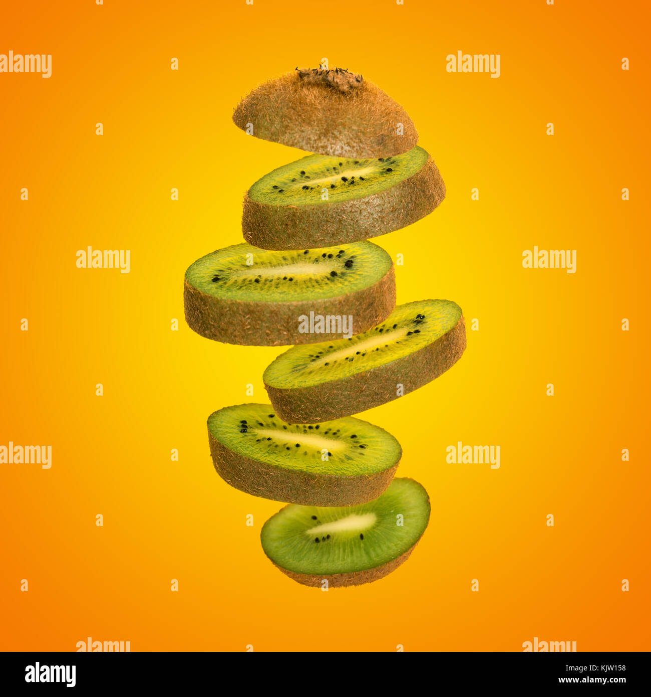 Creative concept with flying kiwi. Sliced kiwi isolated on yellow background. Levity fruit floating in the air Stock Photo