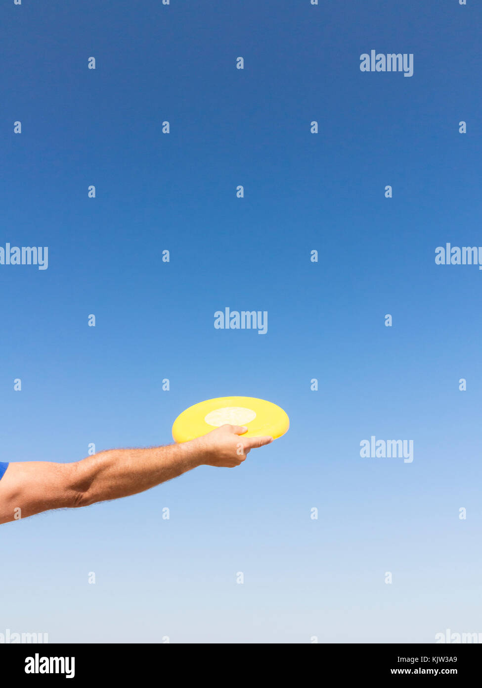 Man throwing a frisbee against blue sky Stock Photo Alamy