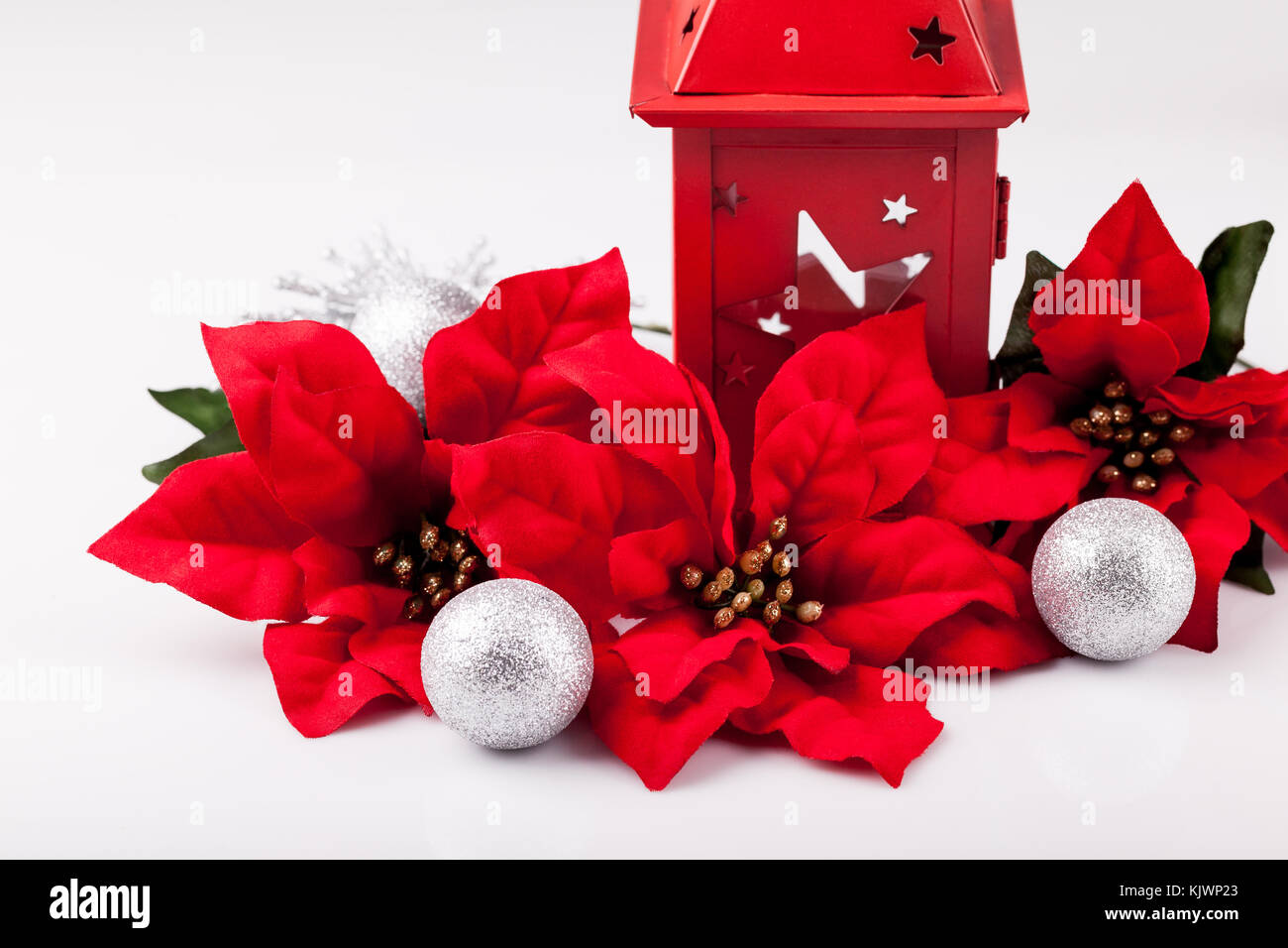 Christmas decoration, red poinsettia and silver baubles on a white background. Stock Photo