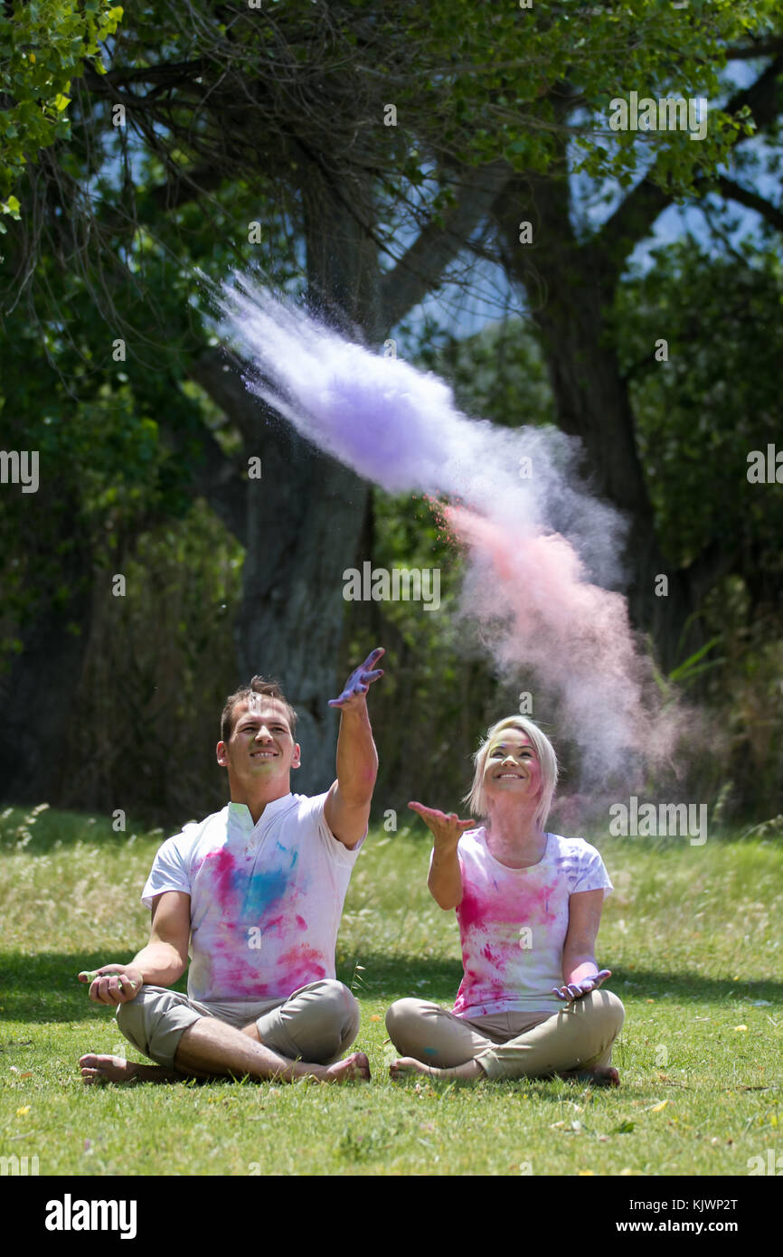 Powder Paint Playing Young funky couple playing with colorful water paint powder on the Holi ...