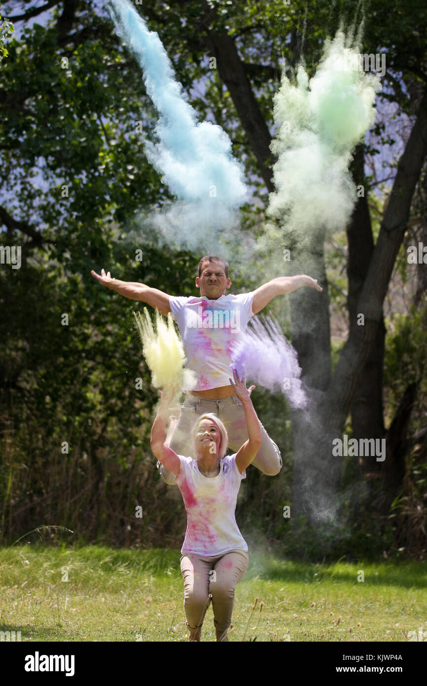 Powder Paint Playing Young funky couple playing with colorful water paint powder on the Holi ...