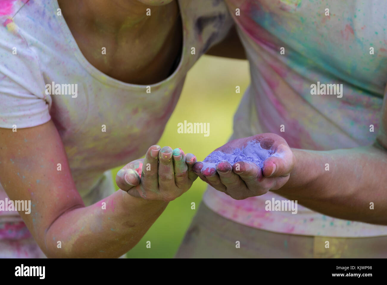 Powder Paint Playing Young funky couple playing with colorful water paint powder on the Holi ...