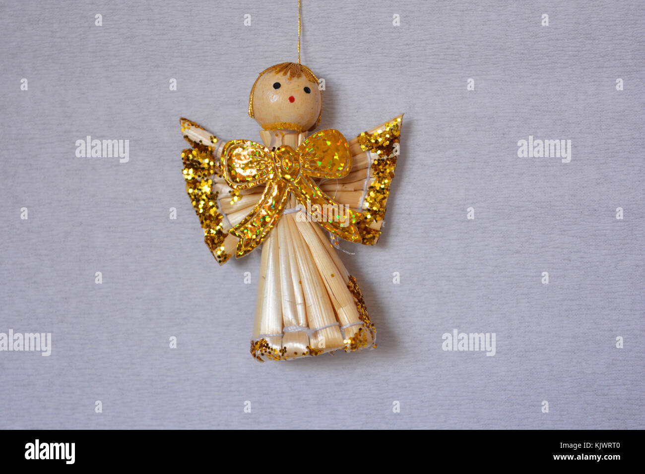Christmas decoration, straw angel with gold glitter wings Stock Photo