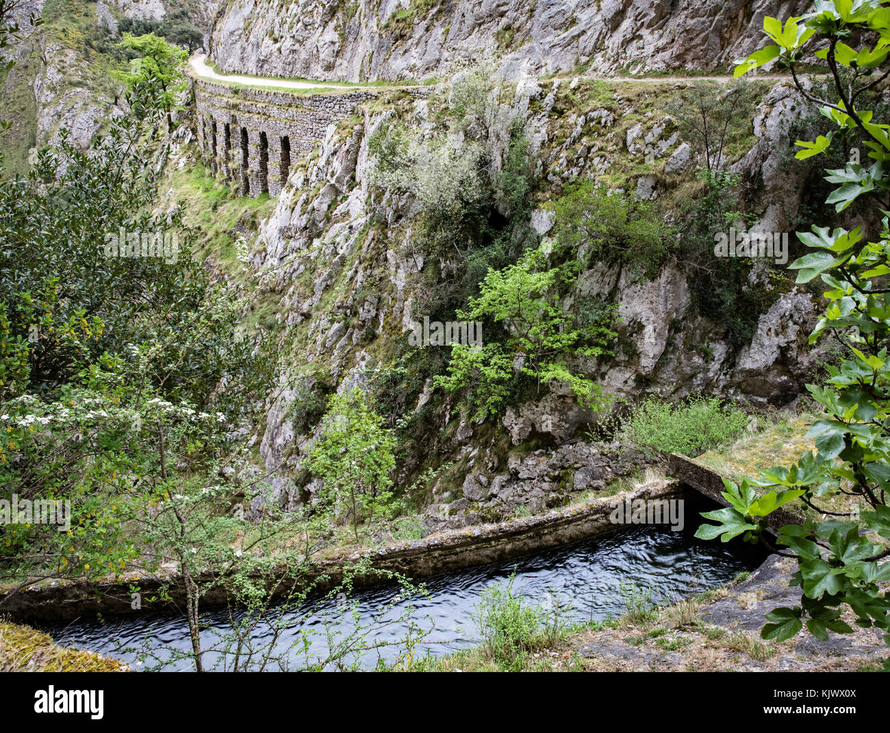 Hydroelectric feeder canal and service path winding through the deep karst limestone chasm of the Cares Gorge in northern Spain Stock Photo