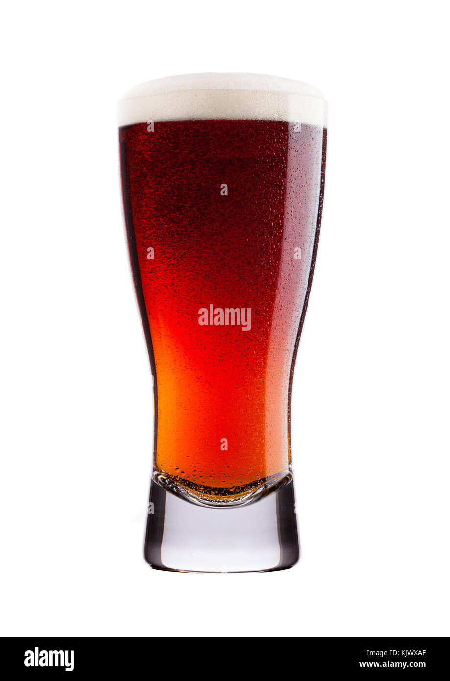 Cold glass of red bitter beer with foam and dew isolated on white