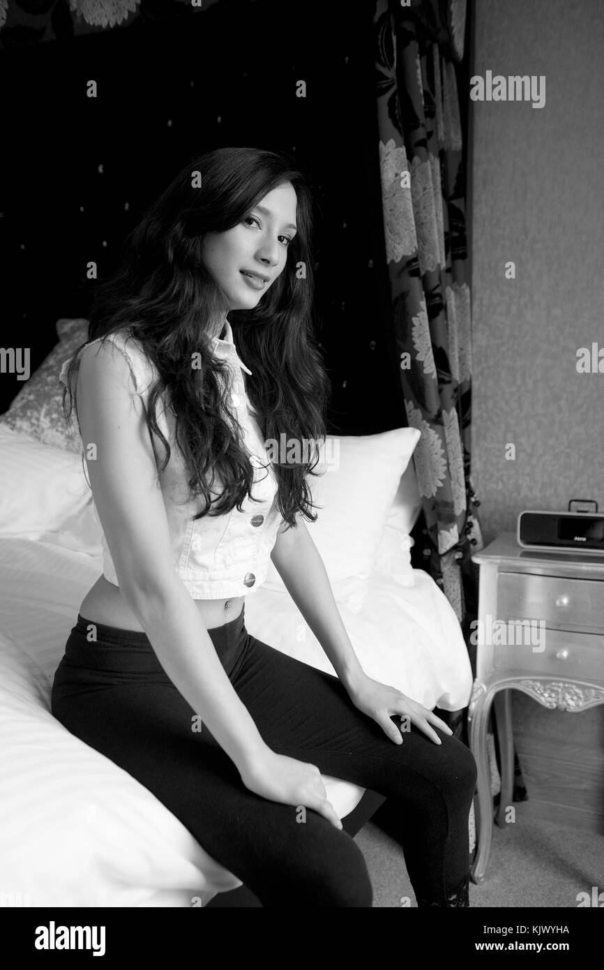 Beautiful brunette girl wearing black leggings in a bedroom location Stock Photo