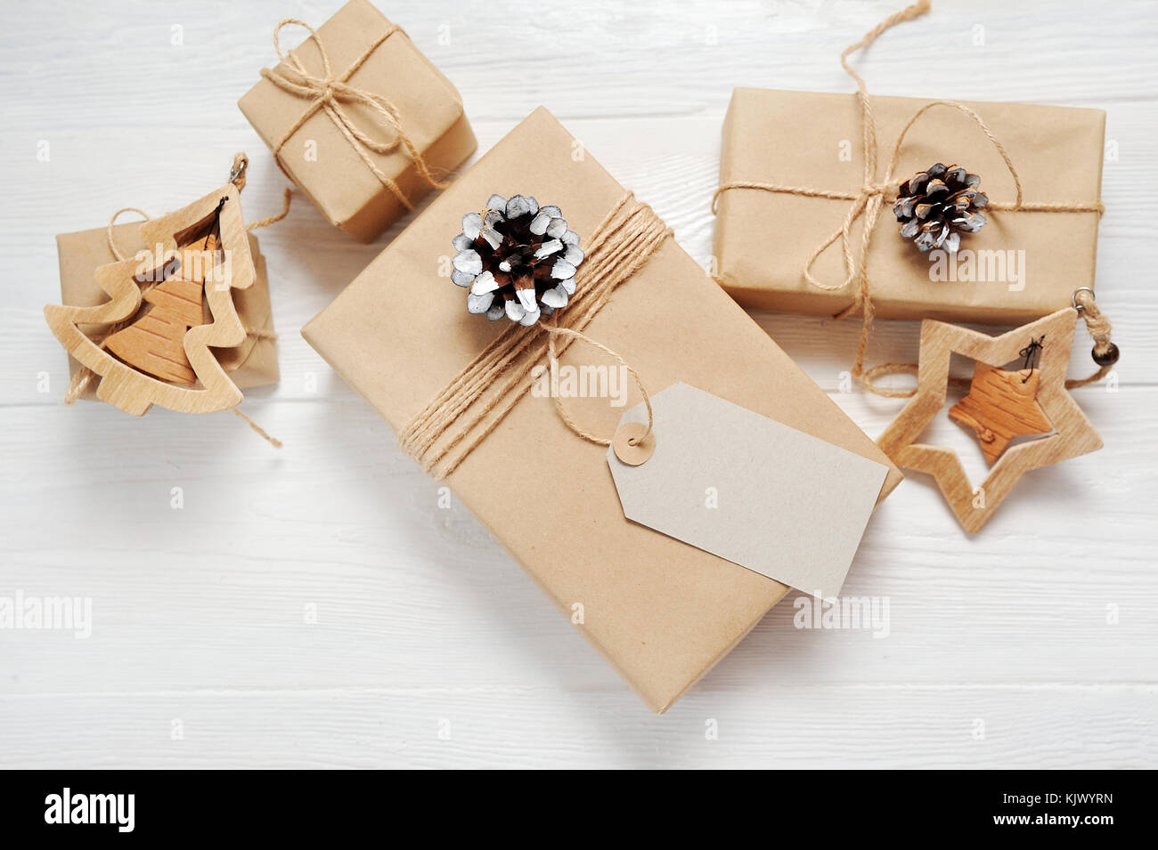 Mockup Christmas present gift box and tag on wooden background in vintage style. Flat lay, top view photo mock up Stock Photo