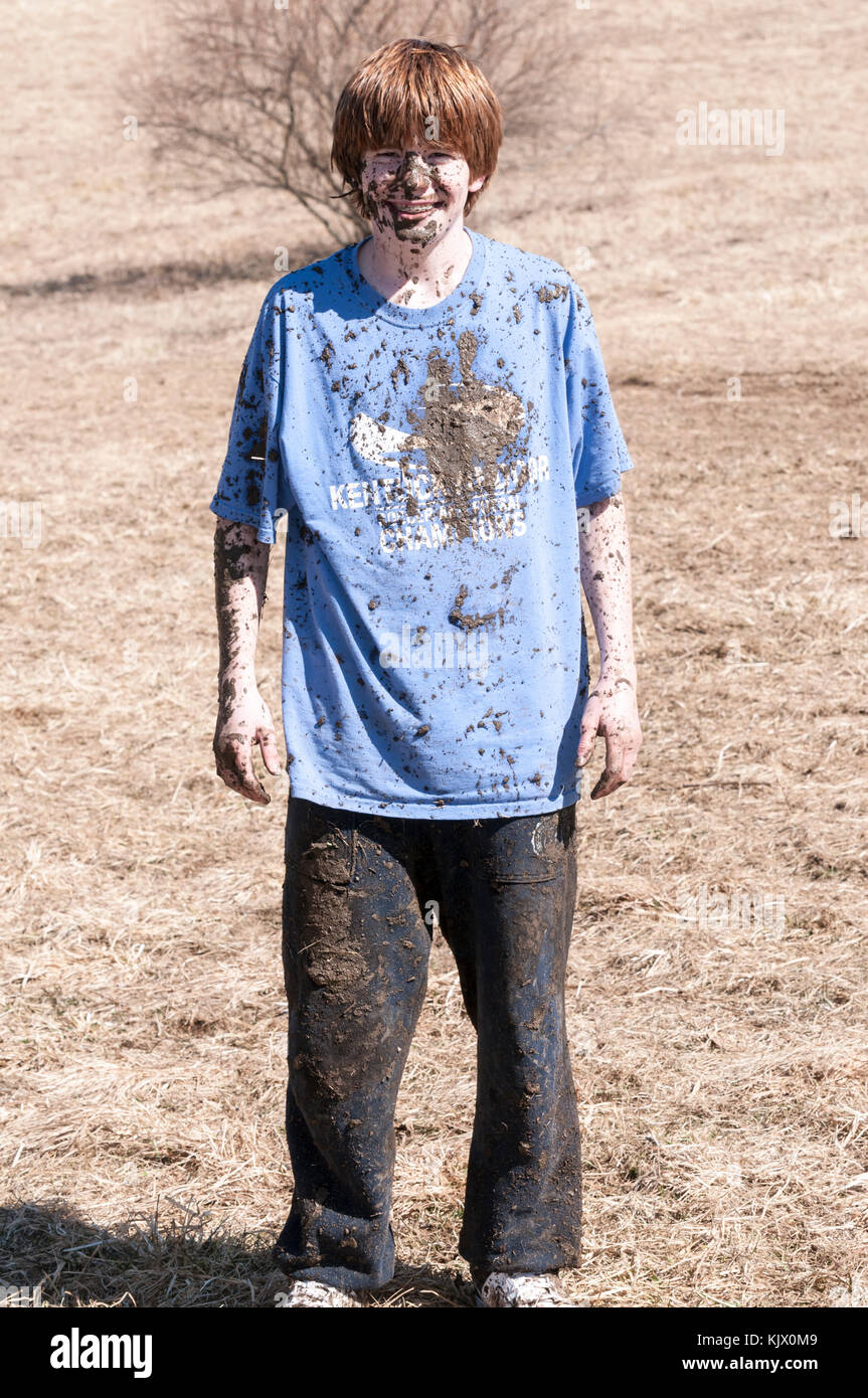 Teenage boy splattered with mud after 4 wheeling in a go kart Stock Photo