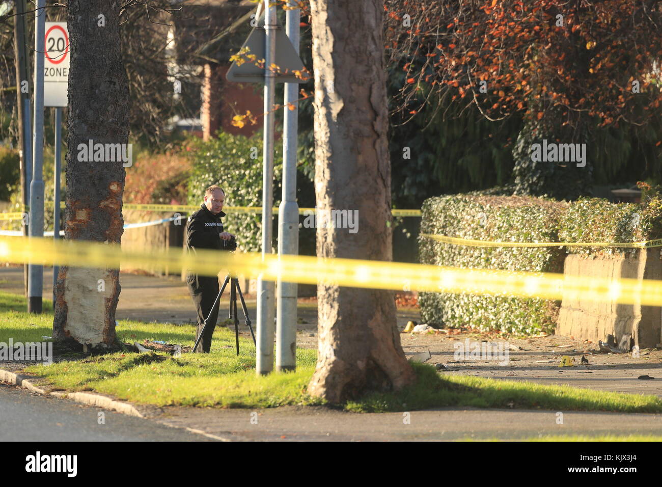 Police at the scene where a stolen car crashed into a tree (left) in
