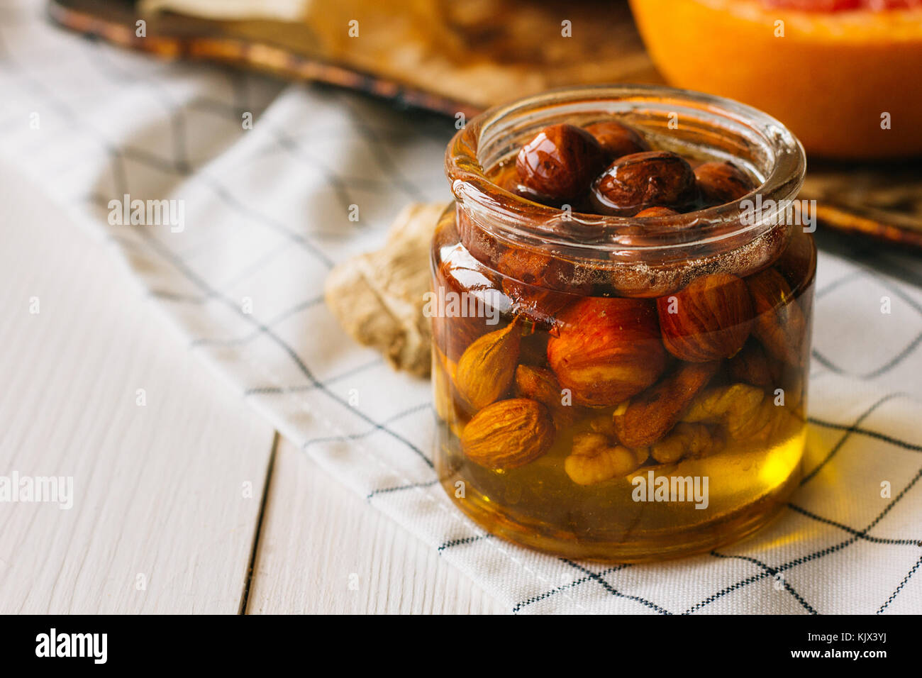 Nuts with honey in glass jar selective focus Stock Photo