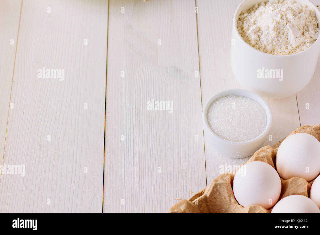 Eggs, flour and sugar on wooden table copy space selective focus Stock Photo
