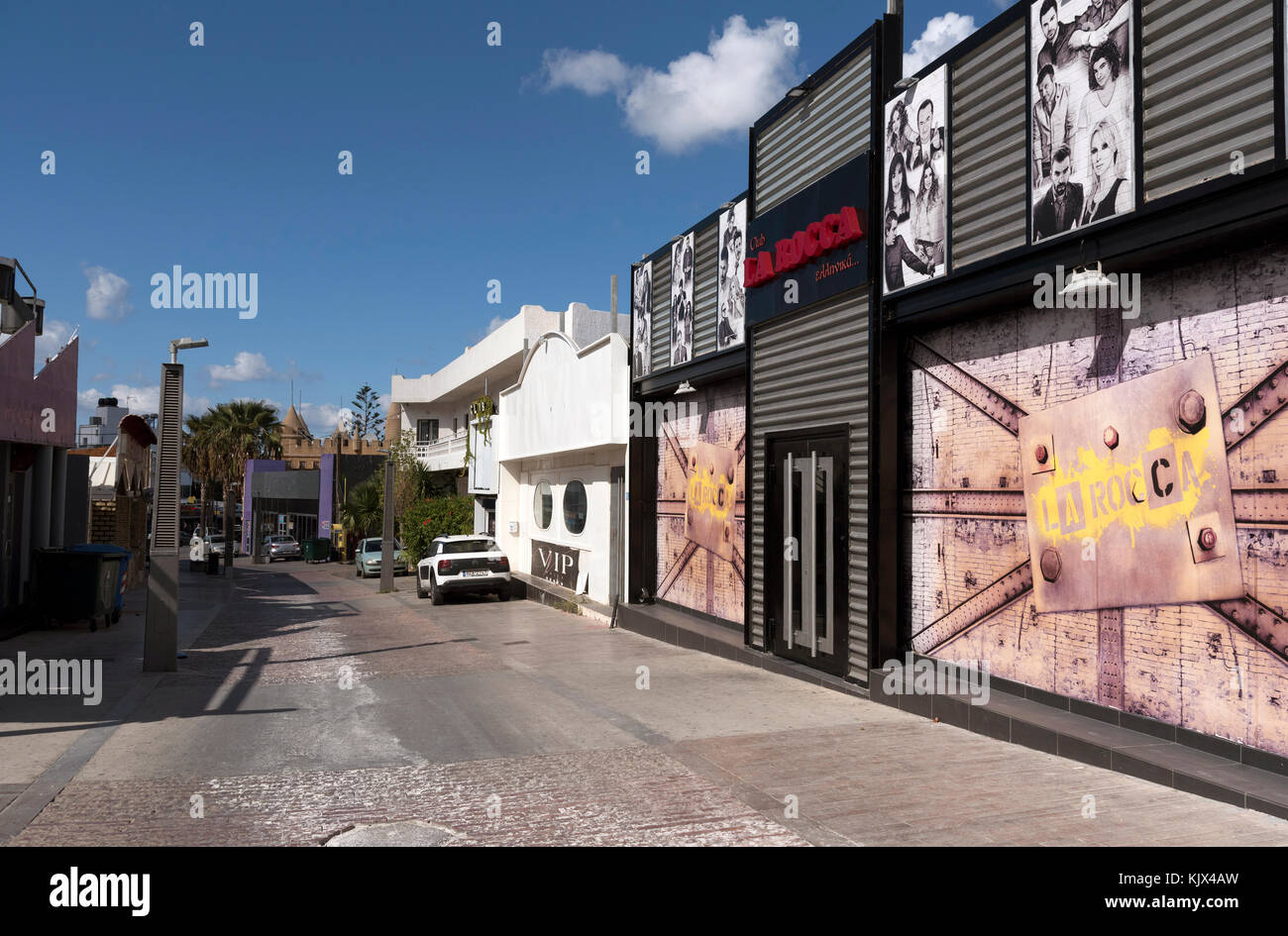 Club Street in Malia, Crete, Greece. October 2017. Night club premises closed for the winter season line the town centre street. Stock Photo