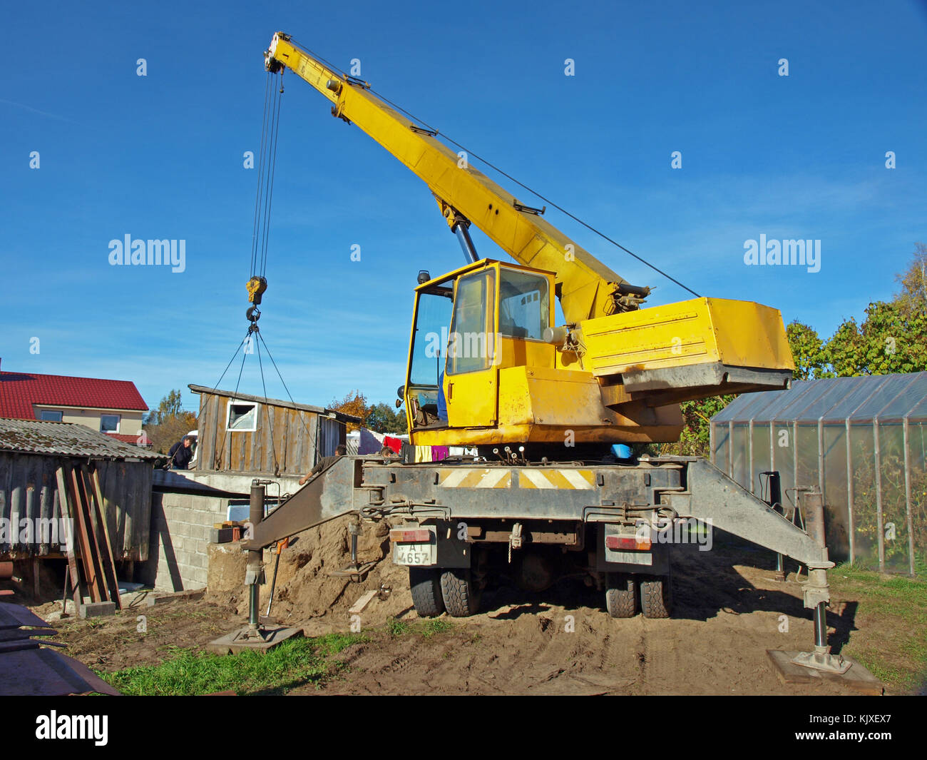 NICA, LATVIA - OCTOBER 12, 2013: Mobile crane mounted on russian truck ZIL is working to cover the new cellar with concrete panels. Stock Photo