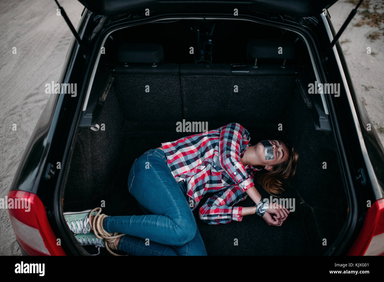 Female victim of a maniac in car trunk, mouth and hands sealed with
