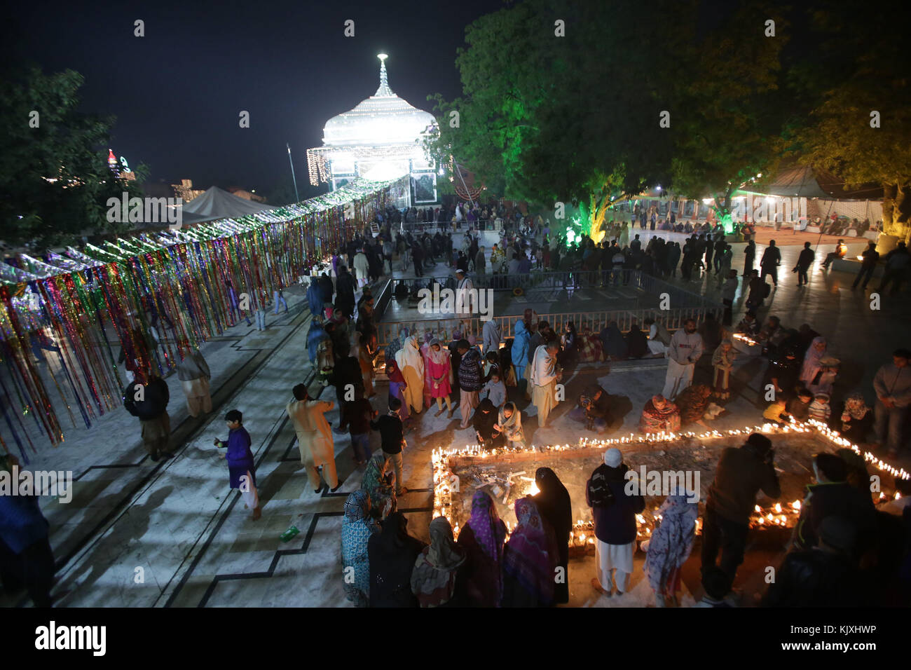 Pakistani Muslim devotees light candles and earthen lamps at the shrine of famous fifteenth