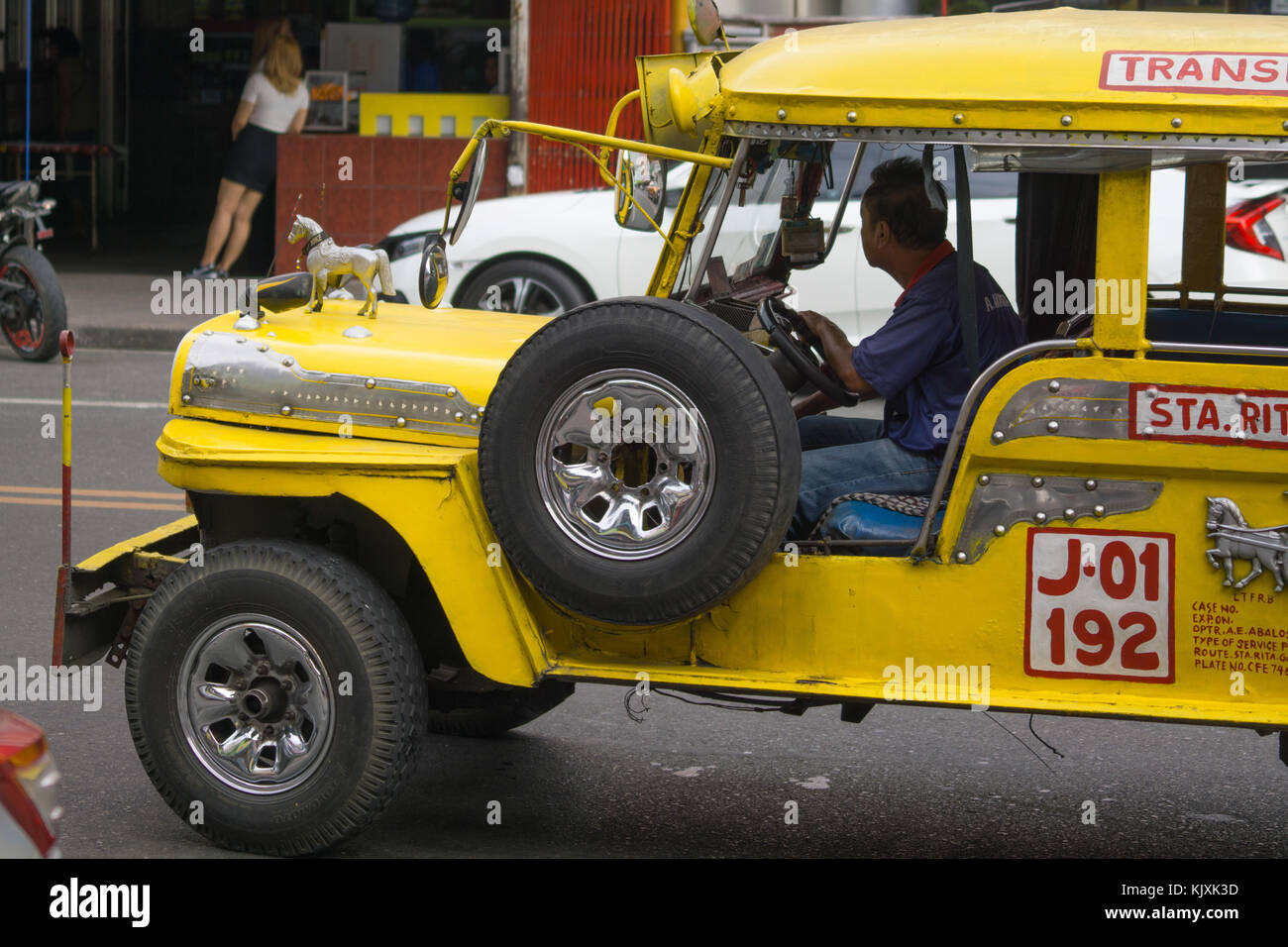 A yellow Public Utility Jeepney Vehicle being driven in Olongapo City,Bataan,Philippines Stock Photo