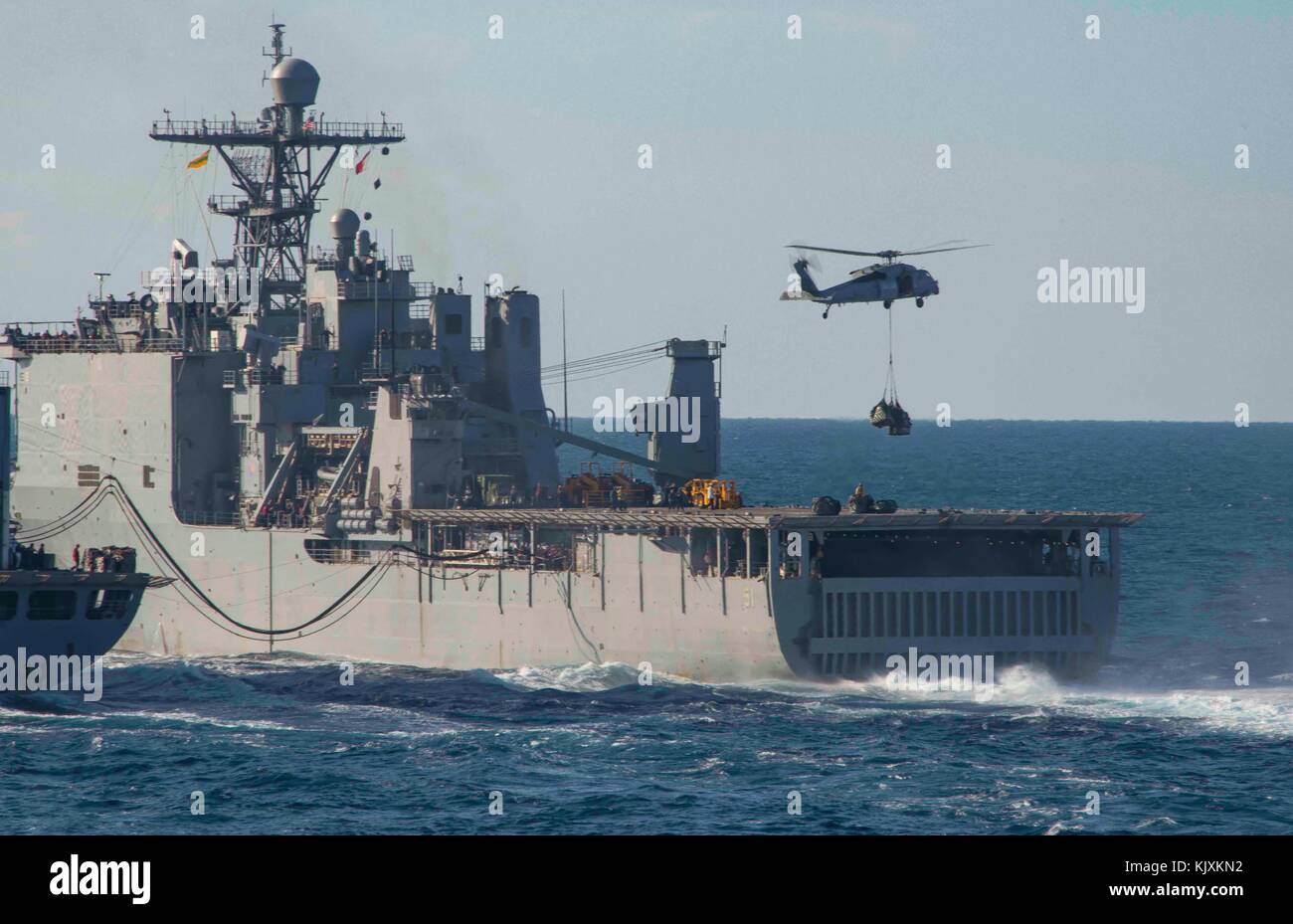 The amphibious dock landing ship USS Oak Hill (LSD 51) receives a vertical replenishment from the fleet replenishment o Stock Photo