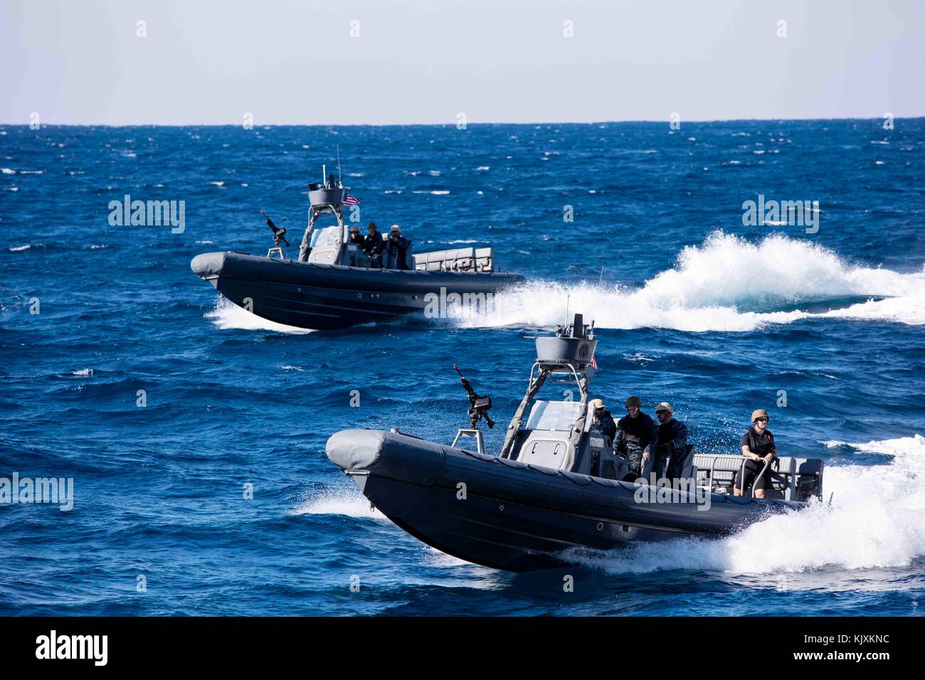 Two 11-meter Navy Special Warfare Rigid Hull Inflatable Boats transit to the amphibious transport Stock Photo