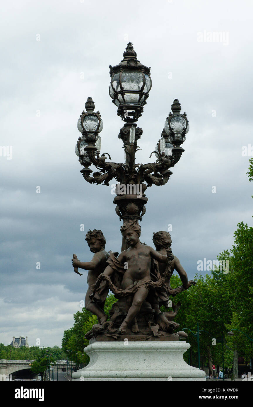 Statues of three Cherubs children standing by the ornamental lamp post ...