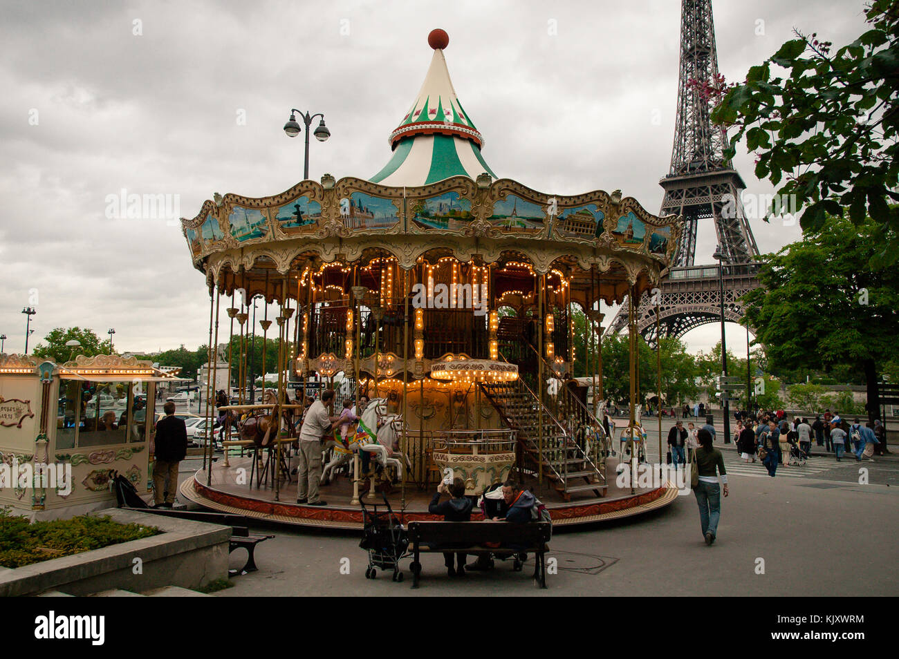 Parisian Carrousel Venitien entertaining tourists at the feet of Eiffel Tower in Paris, France Stock Photo