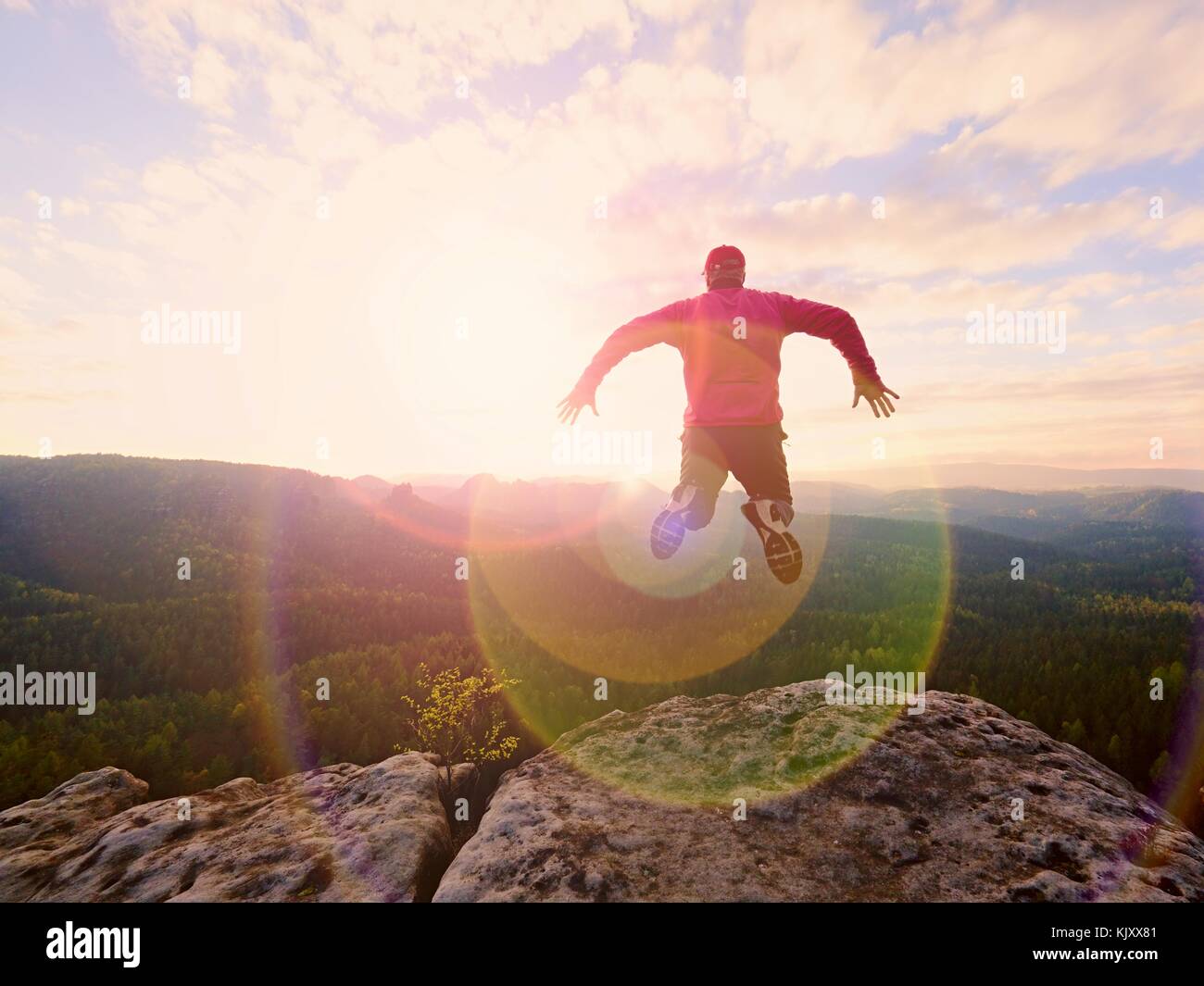 Man jumping from the mountain edge. Man jumping off a cliff without