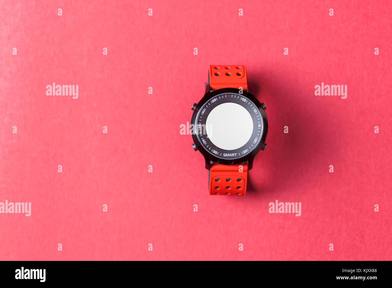 Red smartwatch on red background. Useful for business / tech / sport / any activity presentation background Stock Photo
