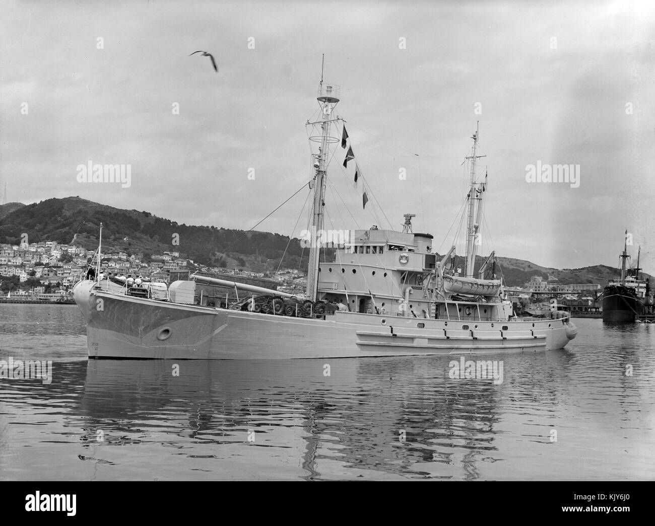 The HMNZS Endeavour, an Antarctic expedition ship, is shown docked in Wellington Harbour in 1956. This vessel played a key role in New Zealand's exploration efforts in Antarctica during the mid-20th century. Stock Photo