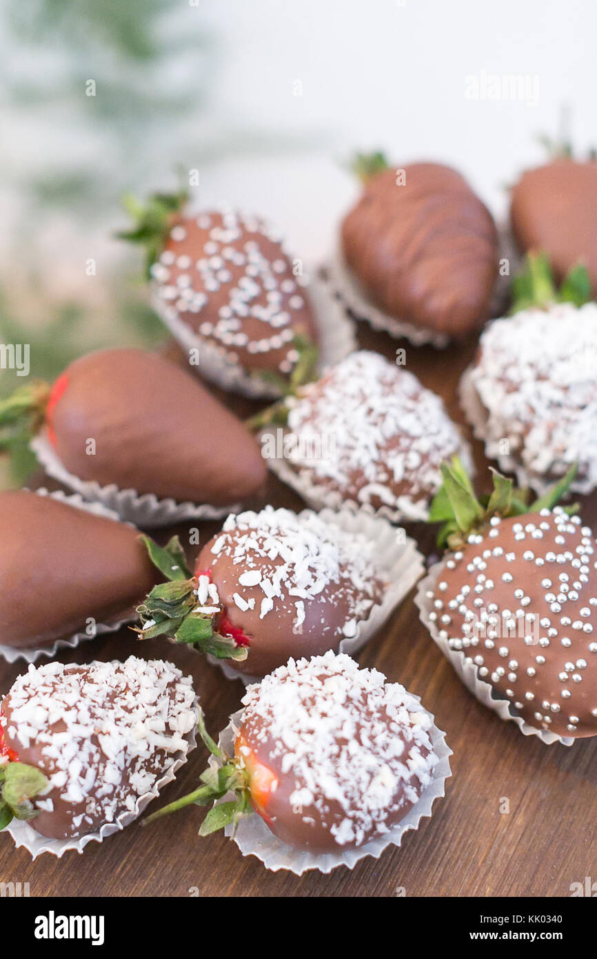 confectionary, food, cooking concept. close up of delicious dessert that is presented by strawberries that are covered with chocolate frosting and coconut shaving Stock Photo