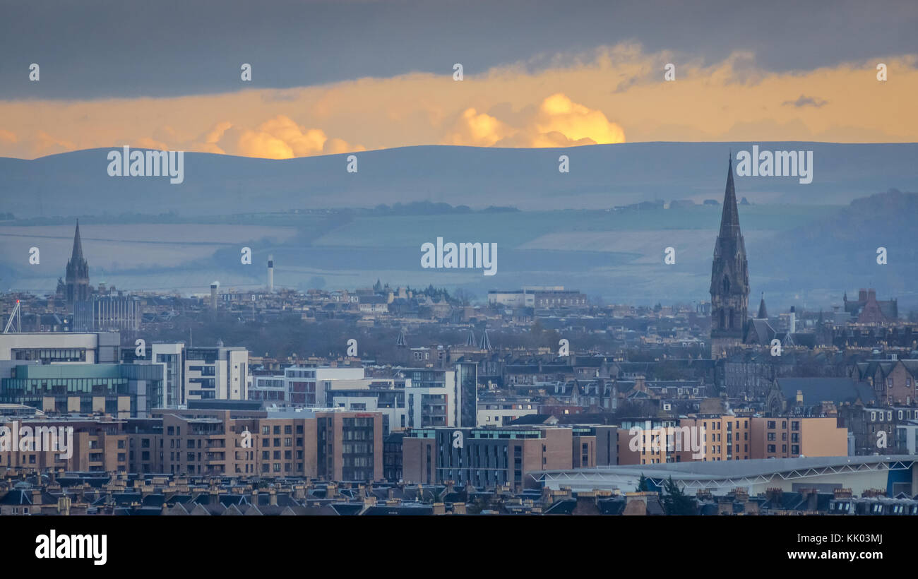 View of Edinburgh skyline, tenements and modern buildings, and church spires at sunset with orange sky, Scotland, UK Stock Photo