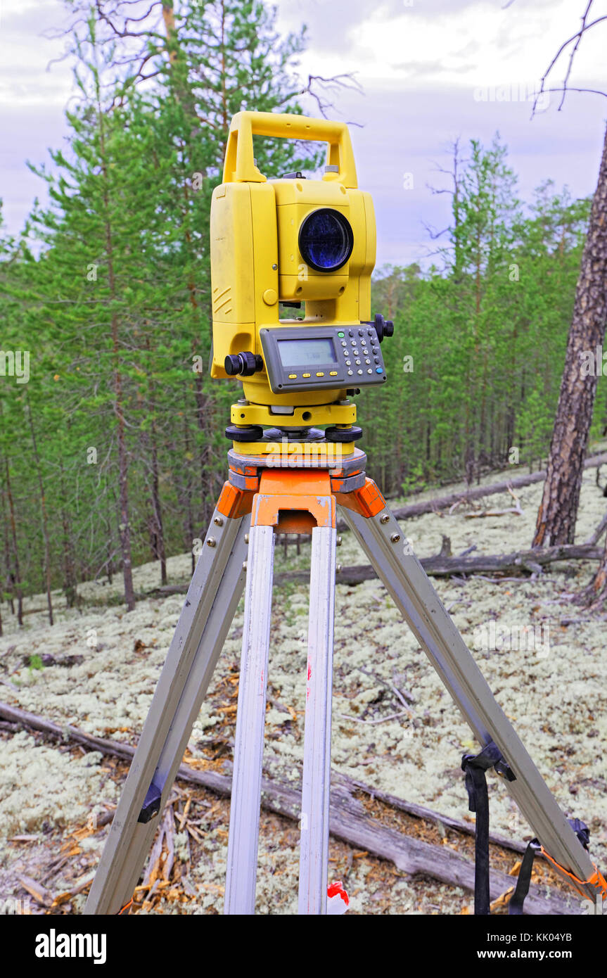 Modern shabby electronic total station mounted on tripod in the forest on  the hillside Stock Photo - Alamy